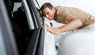 Person inspecting a car&#039;s bodywork