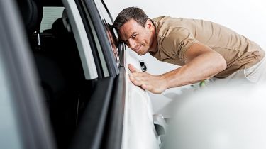 Person inspecting a car&#039;s bodywork