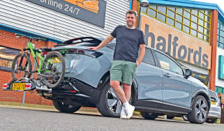 Auto Express head of digital content Steve Walker standing next to the Nissan Ariya outside a branch of Halfords