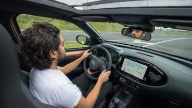 Toyota Aygo X Hybrid - front interior, car being driven by Auto Express senior staff writer Jordan Katsianis