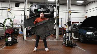 Auto Express news reporter Ellis Hyde standing in a BMW workshop