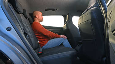 Former Auto Express chief reviewer Alex Ingram sitting in the Renault Megane E-Tech's rear seat