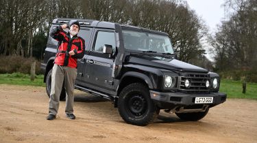 Auto Express senior test editor Dean Gibson lifting dumbells while standing next to the Ineos Grenadier