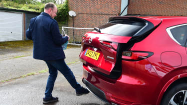 Auto Express chief sub-editor Andy Pringle using under-bumper sensor to open Mazda CX-60 boot