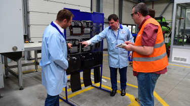 John McIlroy being shown a piece of machinery in the Starkle workshop