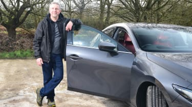 Auto Express senior photographer Pete Gibson leaning on the Mazda 3&#039;s replacement driver&#039;s door