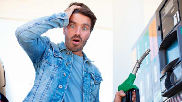 Person looking shocked while holding petrol pump