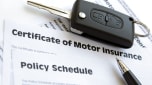 Car insurance documents, car key and pen