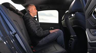 Auto Express deputy editor Richard Ingram sitting in the BMW 330e&#039;s rear seats