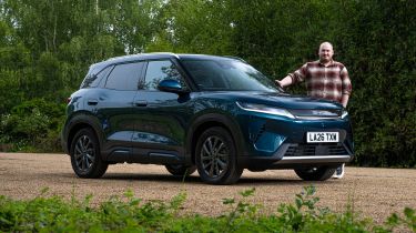 Auto Express news reporter Ellis Hyde standing next to the BYD Atto 2 DM-i