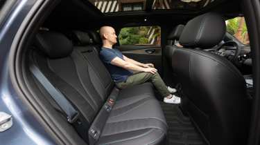 Auto Express chief reviewer Alex Ingram sitting in the BYD Seal 6 Touring&#039;s back seat
