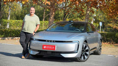 Thomas Geiger standing next to the AUDI E5 Sportback