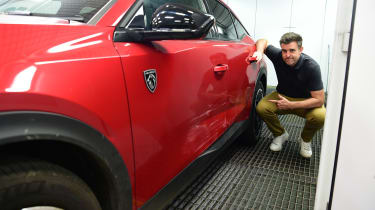 Auto Express head of digital content Steve Walker pointing out the Peugeot 408&#039;s damaged doors 