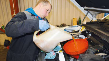 Mechanic topping up engine oil