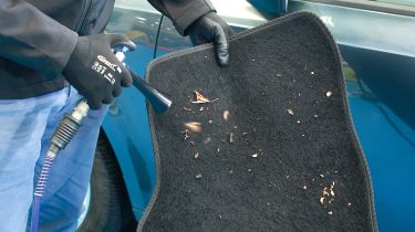 Laser Tools Compact Swirl Gun being used to clean a car mat