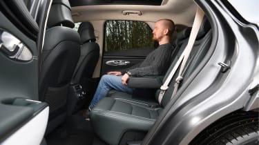Auto Express chief reviewer Alex Ingram sitting in Genesis Electrified GV70&#039;s rear seat