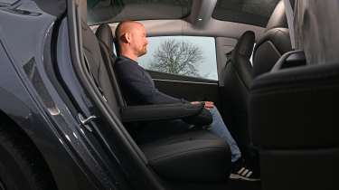 Former Auto Express chief reviewer Alex Ingram sitting in the Tesla Model 3's rear seat