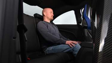 New BMW M2 being driven in the UK - rear seats being sat in by Auto Express chief reviewer, Alex Ingram 