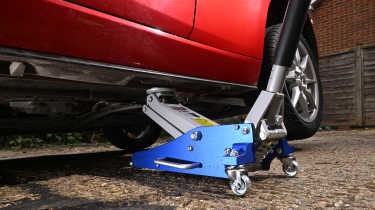 Auto Express Product Awards 2026 - products editor Tom Barnard jacking his car up using the Clarke Racing 1.5 tonne trolley jack