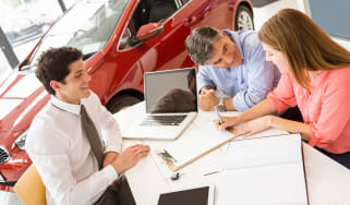 Car salesperson with clients