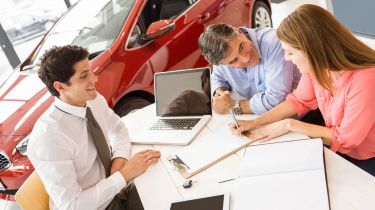 Car salesperson with clients