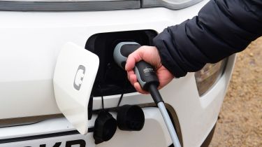 Person plugging a charger into a Kia Soul EV 