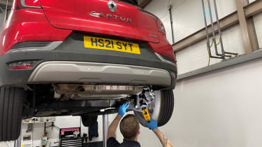 Renault Capture E-Tech: rear suspension being inspected on workshop lift