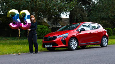 Auto Express pictures editor Dawn Grant standing next to the Renault Clio E-Tech while holding &#039;33&#039; number balloons