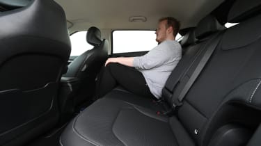 Auto Express news reporter Ellis Hyde sitting in the back seat of the Kia EV6 Horizon