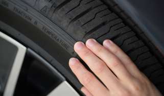 Person inspecting a tyre&#039;s condition