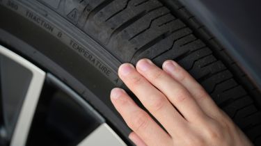 Person inspecting a tyre&#039;s condition