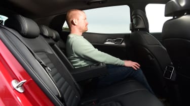 Auto Express chief reviewer Alex Ingram sitting in the back seat of the Kia Sportage