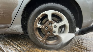 Alloy wheel being cleaned with pressure washer