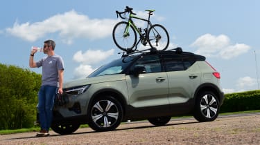 Driving Electric &amp; Carbuyer editor Richard Ingram drinking next to the Volvo XC40
